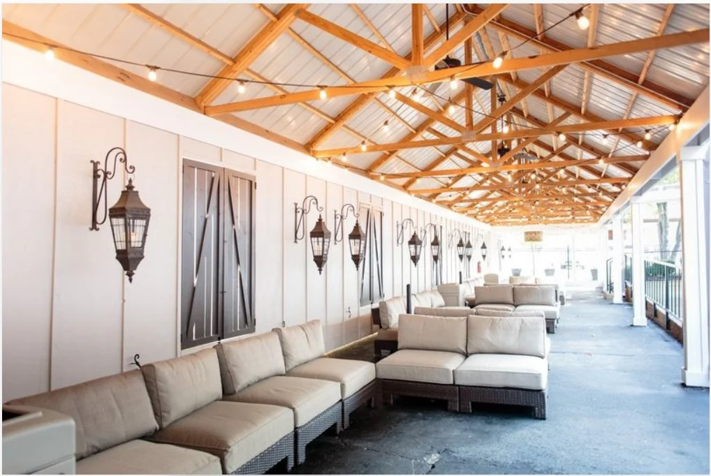 Covered patio and lounge with string lights and outdoor seating at The Bedford (Source: WeddingWire)